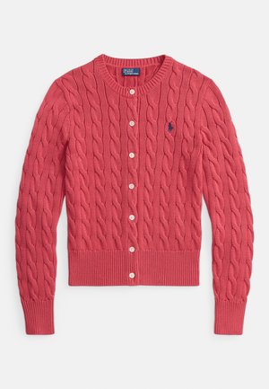 Červený pletený kardigán s vrkočovým vzorom, okrúhlym výstrihom, zapínaním na gombíky a rebrovanými manžetami a lemom. Na ľavej strane na hrudi je malá logo.