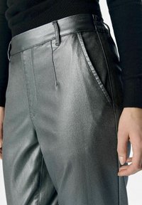Metallische, grijze geplooide broeken met een gladde textuur en tailemdetail. Voorzien van zijzakken en een getailleerde pasvorm.