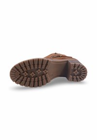 Semelle de botte marron en caoutchouc texturé, dotée d'un motif à crampons profonds pour une meilleure adhérence. Détails en métal et surpiqûres visibles sur la tige.