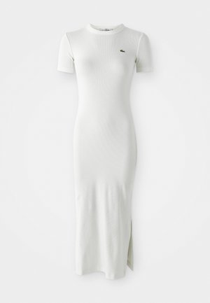 Weißes, geripptes Midikleid mit kurzen Ärmeln, Rundhalsausschnitt und seitlichem Schlitz. Verfügt über ein kleines grünes Logo auf der Brust. Glatte, enganliegende Textur.