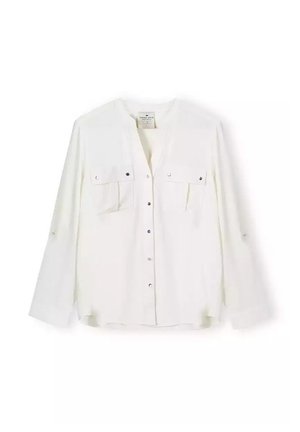 Biała koszula z długim rękawem, dekoltem w serek, dwoma kieszeniami na piersi, z zapięciem na guziki oraz srebrnymi akcentami. Gładki materiał o luźnym kroju.