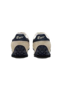 Sneaker in suede beige e navy con suola testurizzata e logo "Tiger" in rilievo sul tallone, caratterizzati da un design atletico classico.