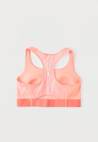 Ροδακινί αθλητικό σουτιέν με σχέδιο racerback, που διαθέτει σταθερή ταινία στο κάτω μέρος, λεία υφή και ραφές κατά μήκος των άκρων.