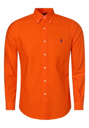 Chemise homme à manches longues boutonnée, en orange vif, avec col et petit logo bleu brodé sur la poitrine gauche.
