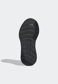 Černá gumová podrážka boty s texturovaným vlnitým vzorem, bočními drážkami a hladkým středovým úsekem, označená "NEMARKUJÍCÍ".