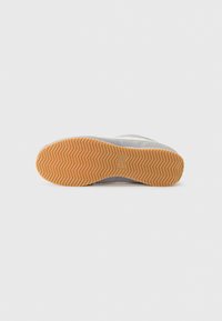 Shoe sole with a herringbone pattern, featuring a tan rubber material. The upper parts appear light gray with subtle accents.