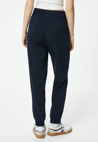 Marina joggers i mjukt material, med ett smockat midjeband och elastiska manschetter, designade för komfort och rörelsefrihet.
