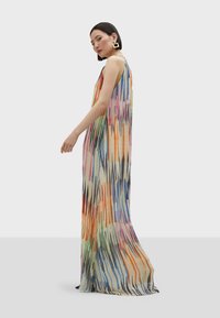 Maxime dress geschikte van lichte stof met een kleurrijk abstract patroon met verticale lijnen in tinten van roze, blauw, groen en oranje.