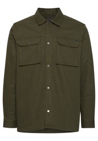 Camisa abotonada verde oliva hecha de una tela resistente con dos bolsillos frontales y broches plateados. Presenta un cuello clásico y un corte recto.