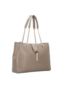 Beige läder tote-väska med dubbla handtag, guld-nyans kedjedetaljer och dekorativt tofs. Har en strukturerad design och mjuk textur.