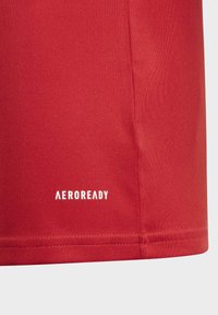 Rød atletisk skjorte med AEROREADY branding, lavet af glat, fugttransporterende stof; har en tætsiddende design og pæn søm.