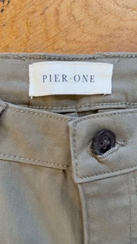 Khaki cotton fabric with a button closure. Features a woven label reading "PIER • ONE." Visible stitching details and smooth texture.