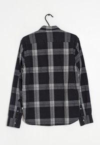 Chemise à manches longues à carreaux noirs et gris, avec col boutonné, boutons aux poignets, et ourlet courbé. Fabriquée en tissu léger.