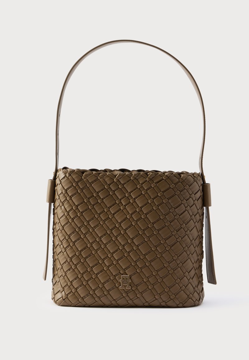 Geantă maro din material împletit, cu o formă structurată, bază plată și o singură curea curbată pentru umăr. Are un logo metalic în față.