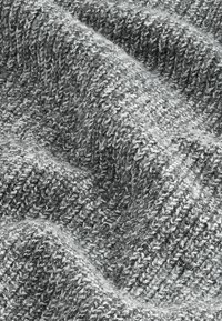 Grau gewebter Stoff mit einer strukturierten Masche, die sich aus verflochtenen Strängen von hellen und dunklen grauen Fasern zusammensetzt und ein weiches, gemütliches Erscheinungsbild erzeugt.