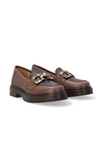 Braune Lederloafers mit runder Zehenform, auffälligen Metallakzenten und einer dicken Gummisohle für zusätzlichen Halt. Glatte Textur mit kontrastierenden Akzenten.