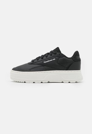 Baskets noires basses Reebok avec semelle épaisse blanche, logo de la marque sur le côté, col rembourré et fermeture à lacets.