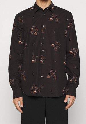 Czarna koszula na guziki z długim rękawem, wzór z brązowymi i pomarańczowymi gitarami oraz ogniskiem, noszona przez osobę z rozluźnionymi ramionami.