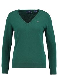 Green V-neck sweater with long sleeves, made from soft knit material. Features a small logo on the left chest and ribbed cuffs and hem.