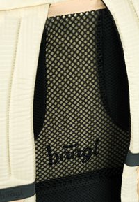 Pannello posteriore di una borsa caratterizzato da un tessuto cremoso texturizzato e materiale a rete nero. Include il logo "baagl" cucito in filo nero.