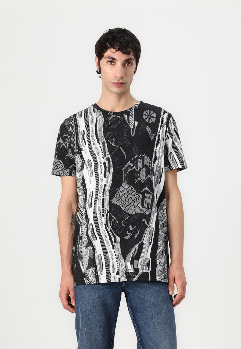Zwart-wit kortemouwen T-shirt met een abstract ontwerp van takken en gebouwen, met een gestructureerd, geweven patroon over het gehele shirt.