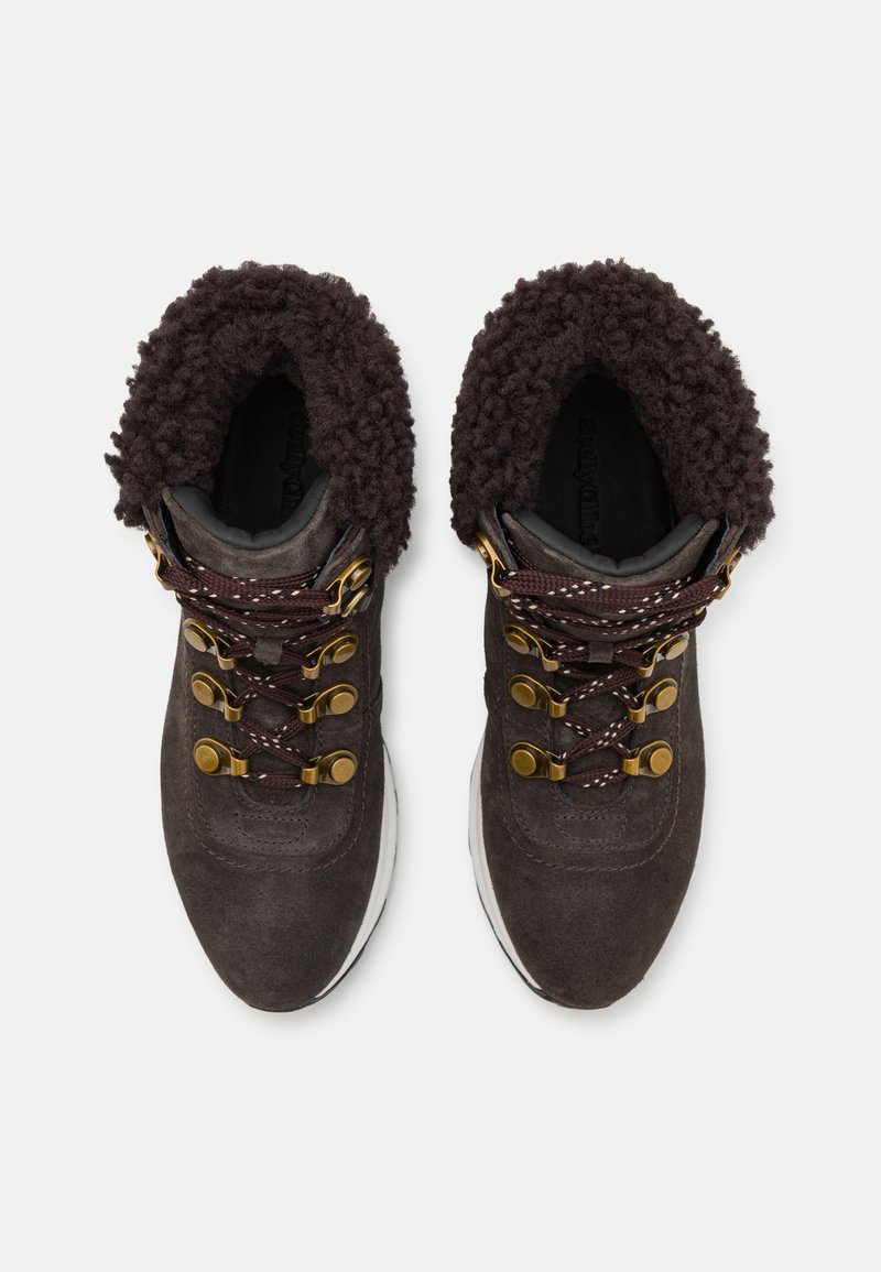 Botas de senderismo de ante gris oscuro con un suave collar marrón, ojales dorados y un sistema de cordones reforzado. Suela de goma blanca.