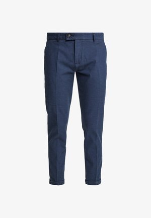 Pantalones de algodón azul marino con un corte ajustado, que presentan pliegues delanteros, cierre de botón y puños enrollados. La tela texturizada añade interés visual.