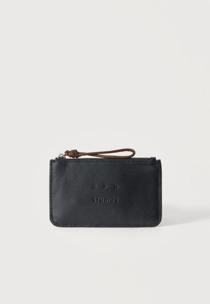 Estuche negro de cuero con cremallera, correa de muñeca marrón y texto en relieve "CPH STUDIOS" en la parte frontal.