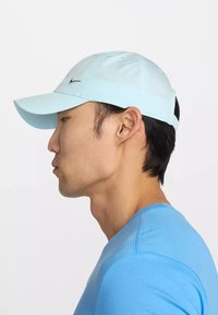 Gorra de béisbol de color azul claro, hecha de tela suave, con visera curvada, detalles cosidos y un pequeño logo negro en la parte frontal.