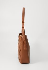 Brown leather bag with woven texture on one side, flat base, adjustable shoulder strap, and gold-tone hardware accents.