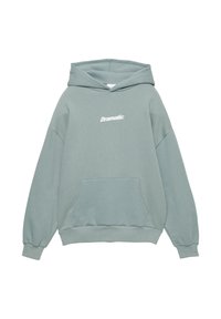 Jasno turkusowy sweatshirt z kapturem, w oversize'owym fasonie, z kieszenią z przodu i napisem "Dramatyczny" wydrukowanym na biało. Miękka faktura, ściągacze u rękawów i u dołu.