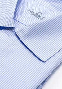 Camicia a quadretti blu chiaro con colletto a punta e logo ricamato. Presenta una superficie liscia e una chiusura con bottoni sul davanti.