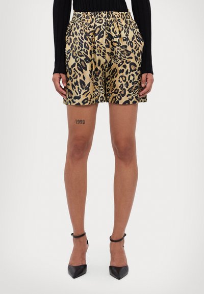 Leopardmønstret shorts i gyldne nuancer med elastisk talje, struktureret form og glat tekstur. Sorte hæle med ankelstropper.