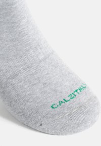 Grau ankle Sock aus weichem, strukturiertem Material. Mit grüner Markenbeschriftung auf der Zehe und einem abgerundeten, nahtlosen Bündchen.