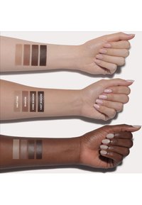 Swatches of four eyeshadow shades on two arms. Top arm features light skin; bottom arm has darker skin. Labels indicate shade names.