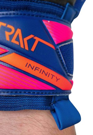 Close-up of a blue and pink sports glove wrist strap with "TRAKT" and "INFINITY" text in orange lettering.