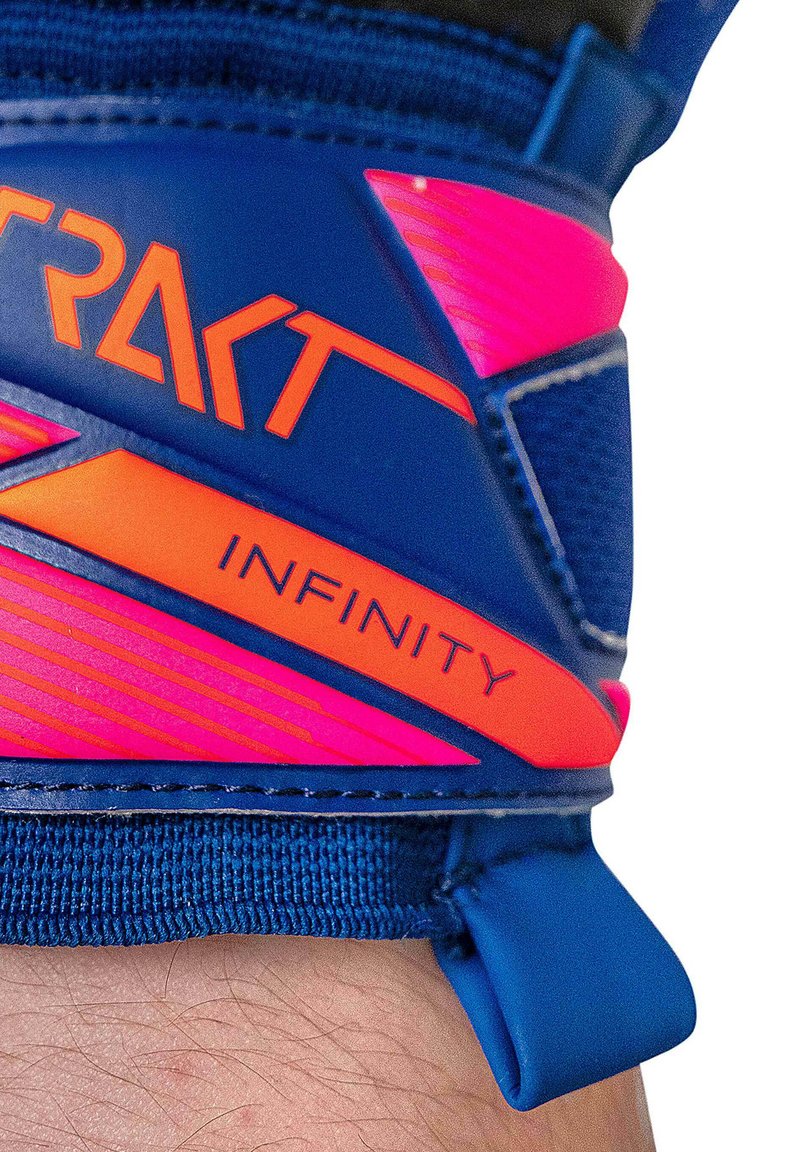Nahaufnahme eines blauen und rosa Sporthandschuh-Handgelenkriemens mit den orangefarbenen Schriftzügen "TRAKT" und "INFINITY".