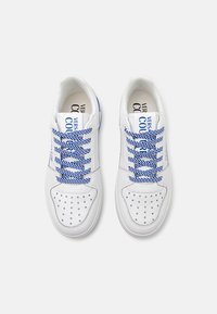 White sneakers with blue patterned laces, perforated toe details, and a logo on the tongue. Smooth leather material and round toe shape.