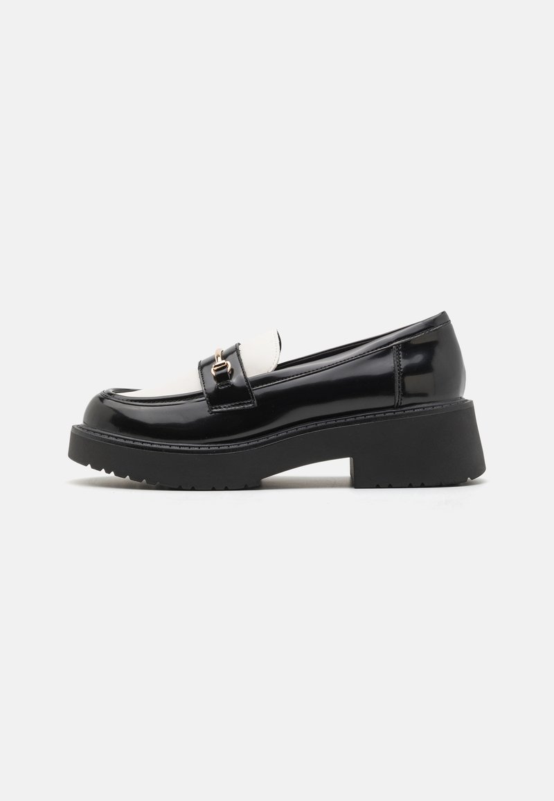 Zwarte lakleren loafers met een witte schacht, voorzien van een gouden gesp detail en een dikke zwarte gestructureerde plateauzool.