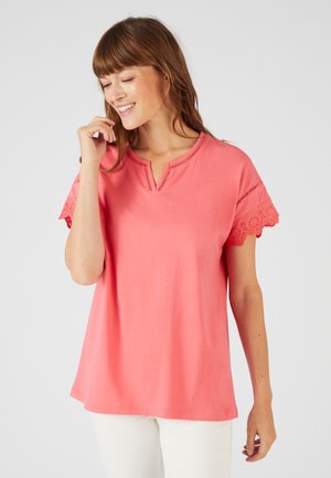 Coral T-shirt with a V-neck and embroidered lace sleeves. Made of soft fabric, featuring a relaxed fit and subtle detailing on the neckline.