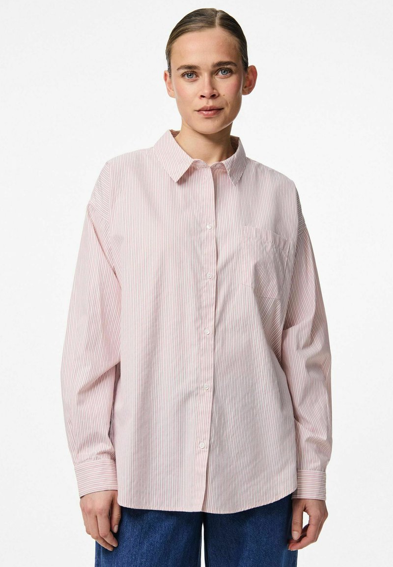 Heled roosa nööpidega särk valgete triipudega, millel on krae, pikad varrukad ja üks rinna-tasku. Valmistatud siledast kangast.