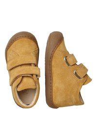 Scarpe in suede tan con due cinturini a strappo, punta rotonda e suola in gomma flessibile. Presentano accenti texturizzati sulla suola.