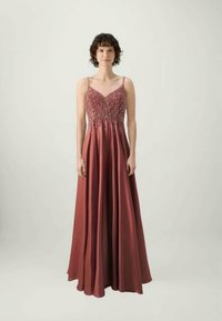 Hosszú bordeaux színű ruha, illeszkedő felsőrésszel, gyöngyökkel díszített dekoltázzsal, és egy lefelé folyó szoknyával, amely a padlóig ér.