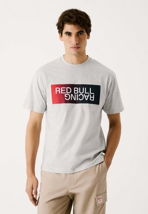 Graues Baumwoll-T-Shirt mit einem rechteckigen "Red Bull Racing"-Logo in Schwarz und rotem Ombre. Rundhalsausschnitt mit kurzen Ärmeln, lockere Passform.