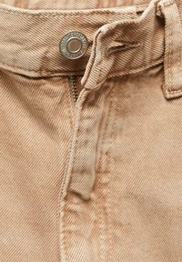 Tessuto di denim beige con una finitura texturizzata, caratterizzato da un bottone metallico, una cerniera e passanti per la cintura. Motivo a righe diagonali distintivo su tutta la superficie.