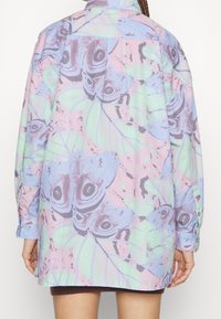 Langärmliges Hemd in Pastellfarben mit einem Motiv aus Schmetterlingen und Blättern, hergestellt aus leichtem Stoff mit lockerer Passform und Knopfmanschetten.