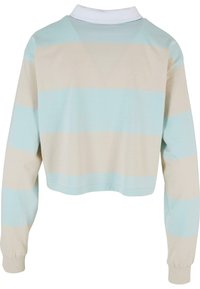 Chemise à manches longues raccourcie en rayures horizontales bleu clair et beige, avec un col blanc et un tissu doux et texturé.