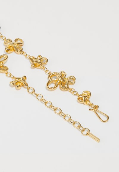 Goldfarbene Metallkette mit organisch geformten Knoten-Links und einem sicheren Hakenverschluss. Glatte Textur mit einem polierten Finish.
