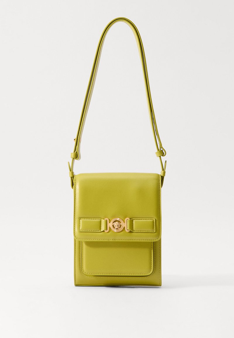 Borsa a mano in pelle verde con una forma strutturata, dotata di una patta anteriore, dettagli in oro e una tracolla sottile e regolabile.