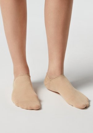 Beige Unsichtbare Socken aus glattem, elastischem Material, mit einem nahtlosen Design und einer weichen Textur sowie einer abgerundeten Zehenpartie.